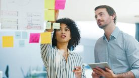 Shot of a young businessman and businesswoman using a digital tablet while having a brainstorming session in a modern office