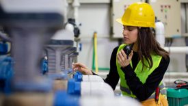 Young worker reporting problem in boiler room using walkie talkie. Shallow DOF. Developed from RAW; retouched with special care and attention; Small amount of grain added for best final impression. 16 bit Adobe RGB color profile.